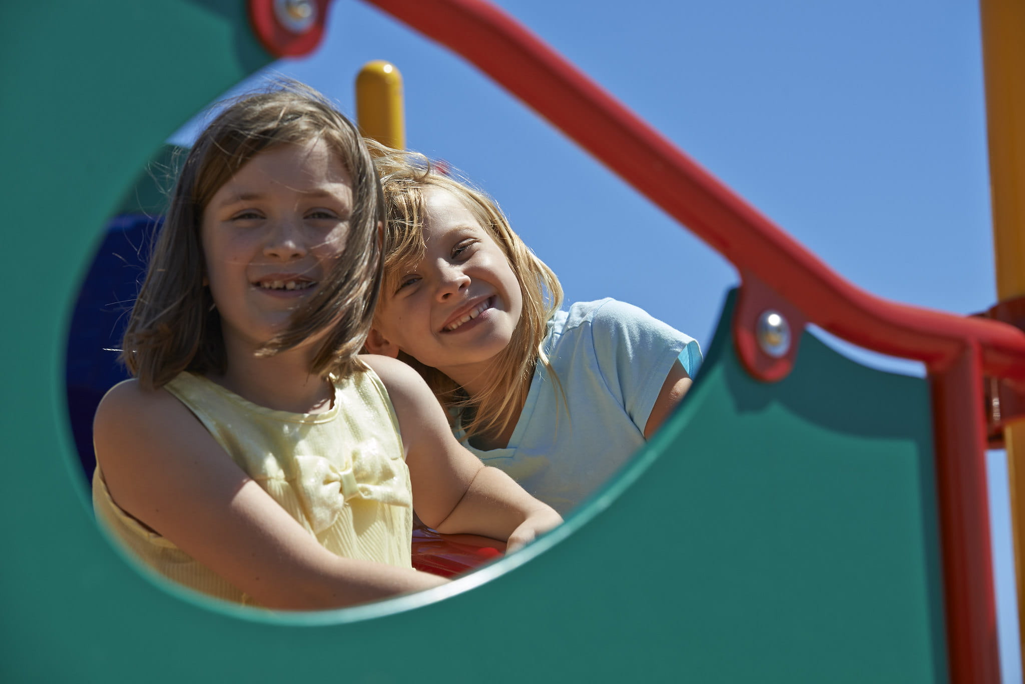 Two girls sitting on top of playground