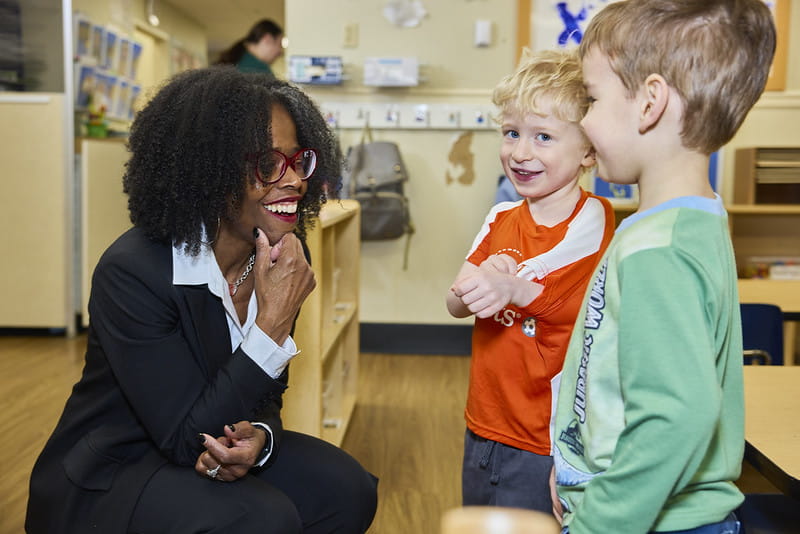 Woman talking with two children on their level